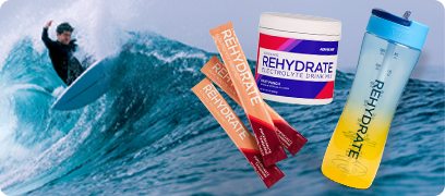 Rehydrate Fruit Punch canister, Pomegranate Tangerine stick, and a Rehydrate labeled shaker bottle against a man surfing on waves as the background.