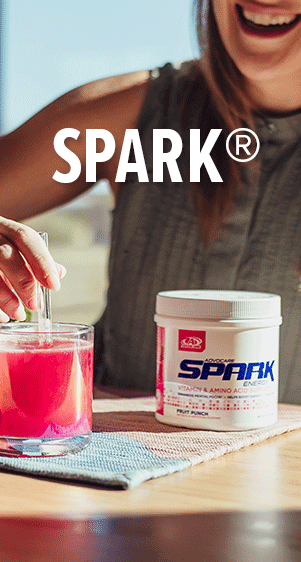 Spark&reg;. A woman mixing Spark Fruit Punch powder into a glass of water