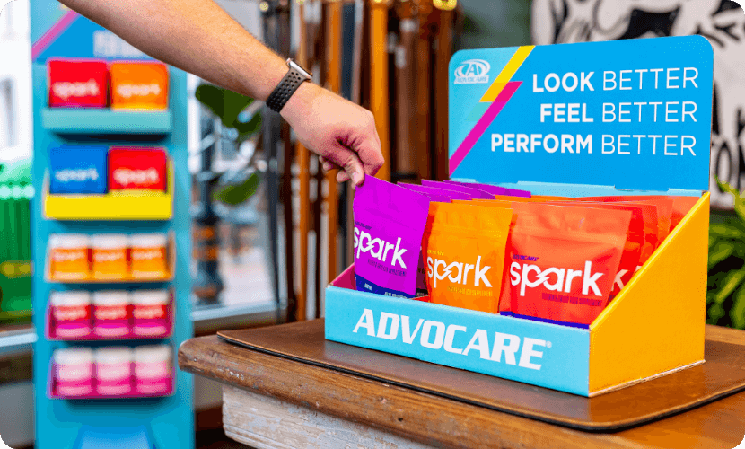 A hand reaching for Spark Grape gusset bag from the Exclusive AdvoCare Store Display