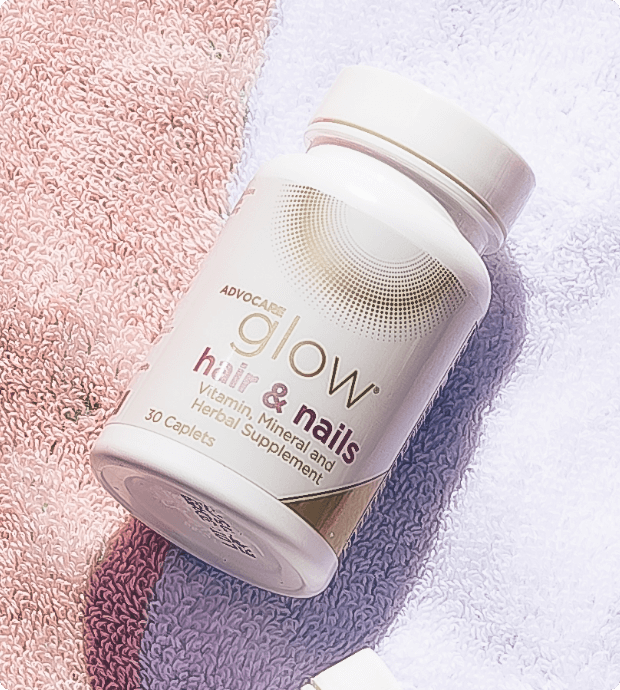 Bottle of Glow Hair & Nails on a beach towel.