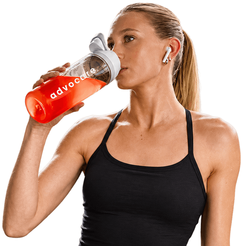 Woman in workout clothes drinking from an AdvoCare branded bottle.