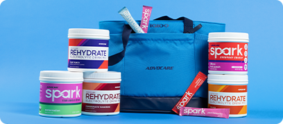 AdvoCare Spark & Rehydrate products sitting next to and in an AdvoCare branded Blue Igloo Cooler bag.